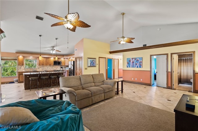 10610 Habitat Trl, Bokeelia, FL 33922 - living area with ceiling fan, high vaulted ceiling, light tile patterned floors, and baseboards
