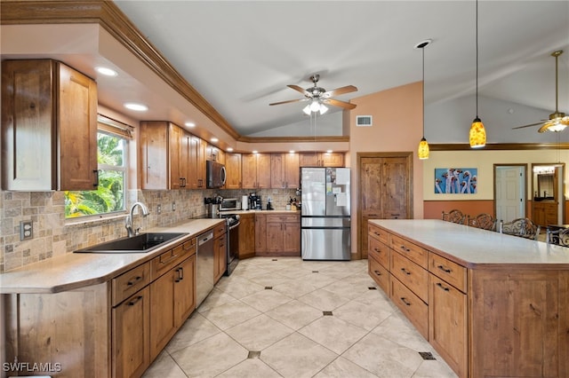 kitchen with sink, stainless steel appliances, tasteful backsplash, pendant lighting, and vaulted ceiling