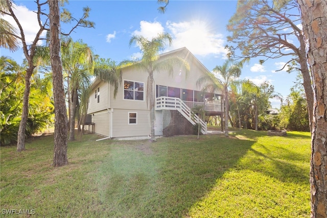 10610 Habitat Trl, Bokeelia, FL 33922 - back of house featuring a sunroom, stairway, and a yard