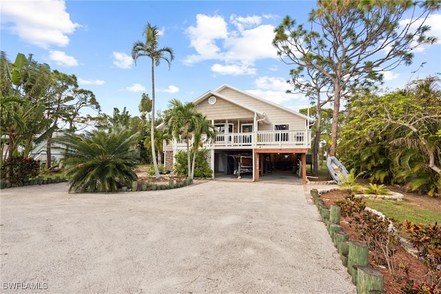 10610 Habitat Trl, Bokeelia, FL 33922 - coastal inspired home featuring a carport, driveway, and covered porch