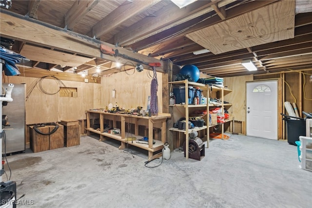 basement with a workshop area and wooden walls