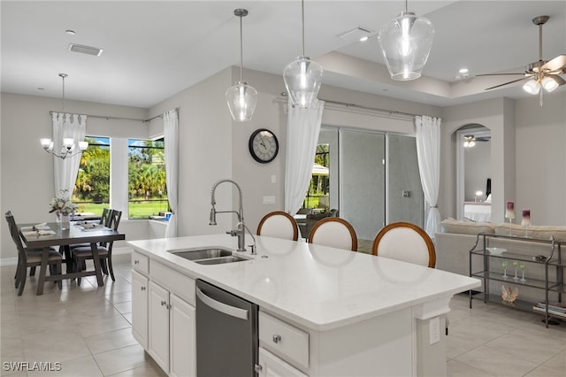 kitchen with sink, a kitchen island with sink, white cabinetry, dishwasher, and ceiling fan with notable chandelier