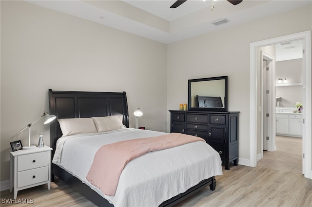 bedroom with ceiling fan, light wood-type flooring, and connected bathroom