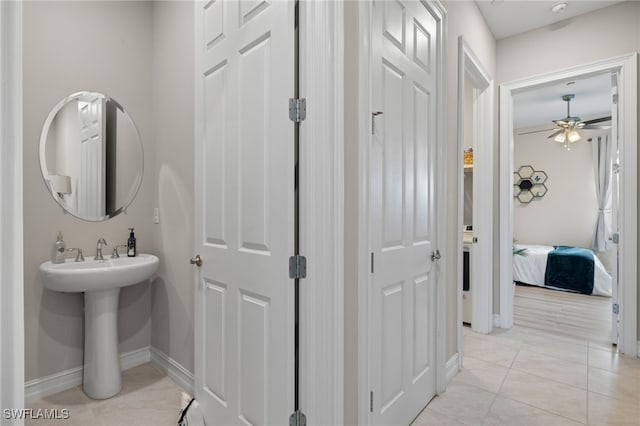 bathroom with ceiling fan and tile patterned floors