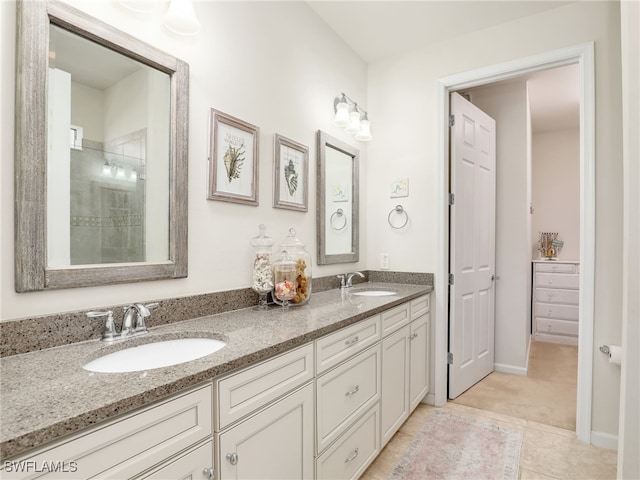 bathroom featuring tile patterned floors, vanity, and a tile shower