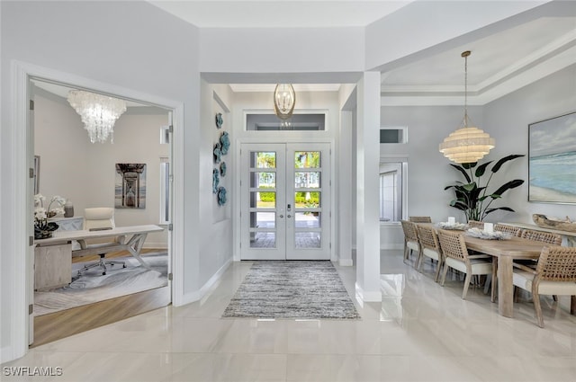 entrance foyer with an inviting chandelier and french doors