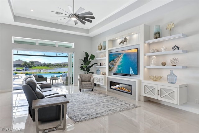 living area featuring ceiling fan, a raised ceiling, crown molding, and built in shelves