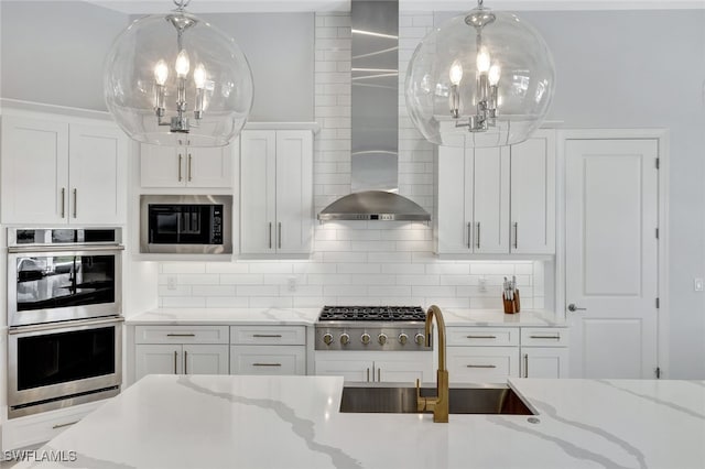 kitchen featuring light stone countertops, decorative backsplash, white cabinetry, appliances with stainless steel finishes, and sink