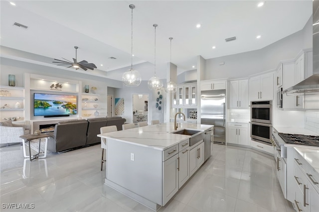 kitchen featuring white cabinets, a center island with sink, appliances with stainless steel finishes, and sink