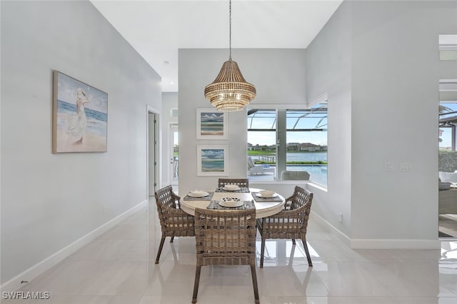 dining area with an inviting chandelier, light tile patterned floors, and a water view