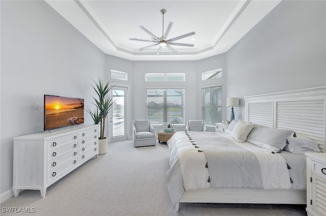 carpeted bedroom featuring a towering ceiling, a raised ceiling, and ceiling fan