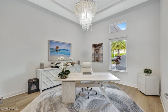 office space with light hardwood / wood-style floors and a chandelier