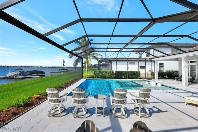 view of pool with a yard, a water view, glass enclosure, and a patio area