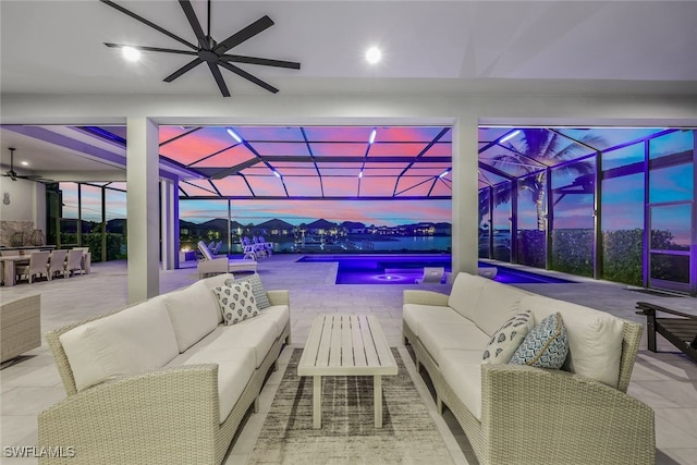 patio terrace at dusk featuring an outdoor hangout area, ceiling fan, and glass enclosure