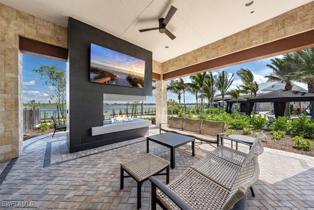 view of patio with ceiling fan, a water view, and outdoor lounge area