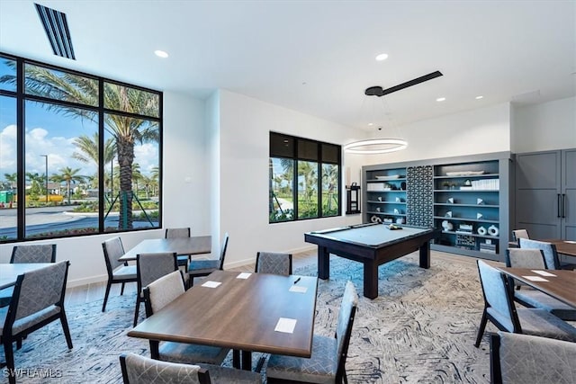 dining space featuring billiards, built in shelves, and hardwood / wood-style flooring