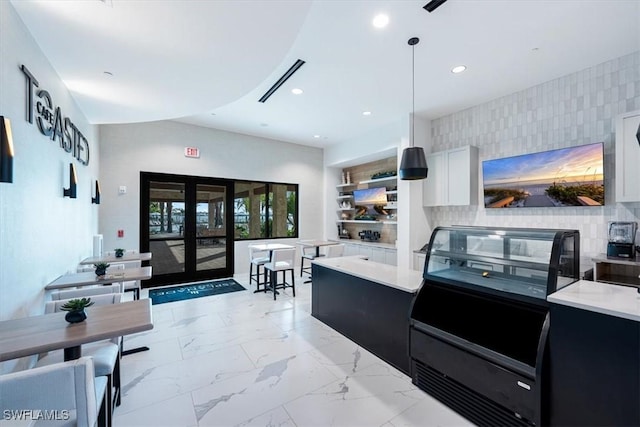 kitchen with white cabinets, pendant lighting, french doors, and tasteful backsplash