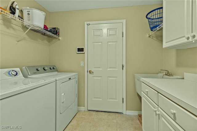 washroom with washer and clothes dryer, cabinets, and light tile patterned flooring