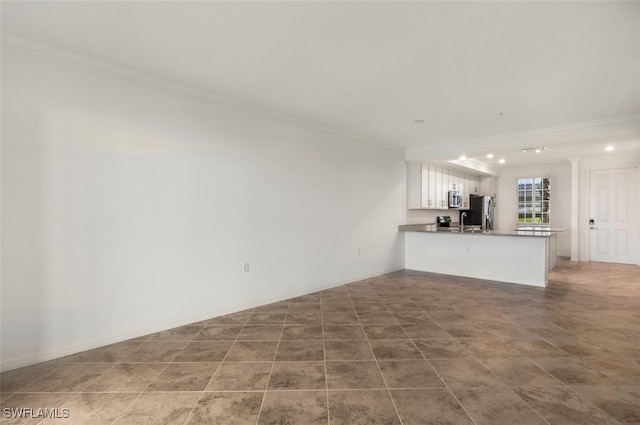 unfurnished living room featuring ornamental molding and sink