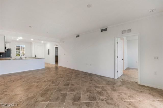 unfurnished living room featuring crown molding and sink