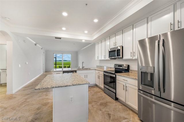 kitchen featuring light stone countertops, stainless steel appliances, white cabinetry, and sink