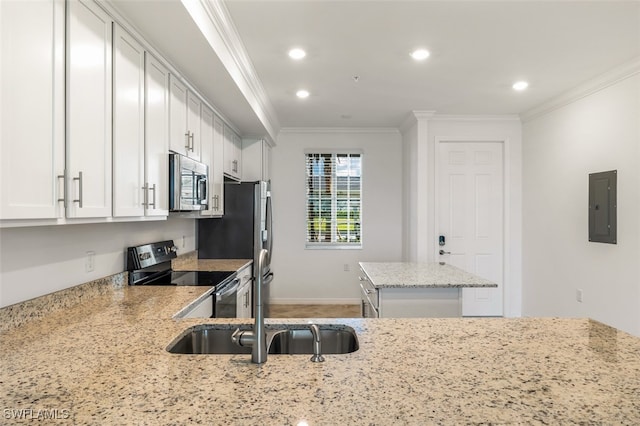 kitchen with light stone counters, white cabinets, stainless steel appliances, ornamental molding, and electric panel