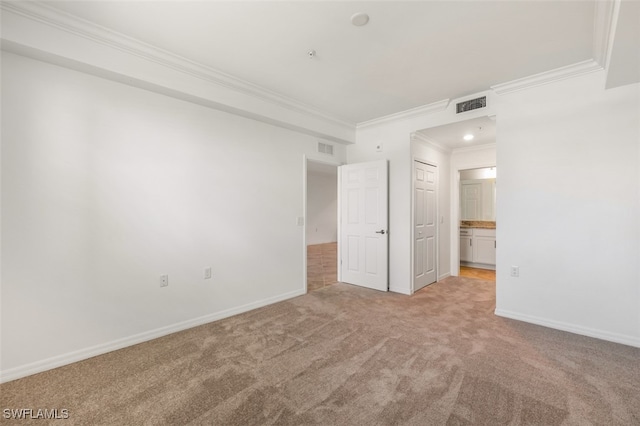 unfurnished bedroom featuring light carpet, ensuite bathroom, and crown molding