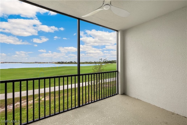 unfurnished sunroom featuring a water view and ceiling fan