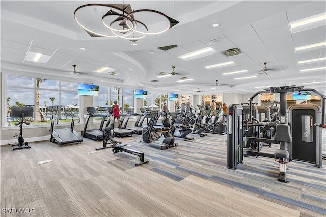 gym with a paneled ceiling, light carpet, and ceiling fan