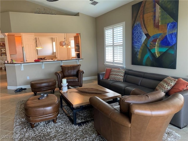 tiled living area with baseboards, vaulted ceiling, and visible vents