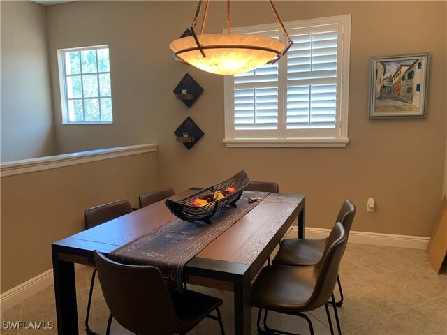 dining area featuring light tile patterned flooring and baseboards