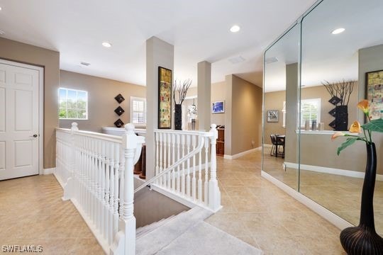 hallway with baseboards, an upstairs landing, recessed lighting, and tile patterned floors