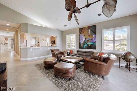 tiled living room featuring lofted ceiling and ceiling fan