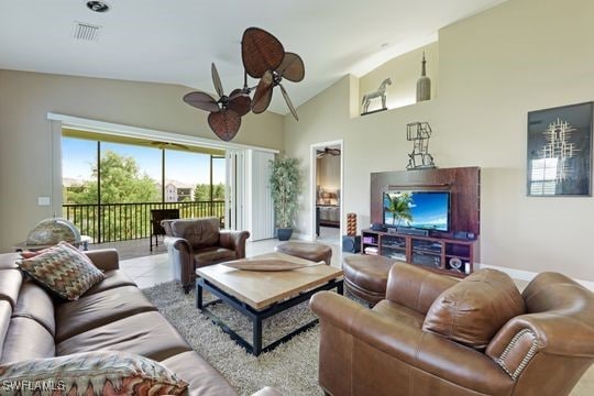 living room with lofted ceiling, ceiling fan, and tile patterned floors