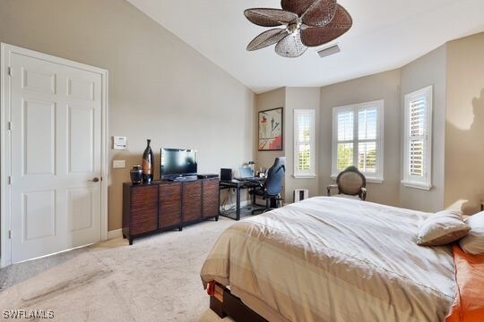 bedroom featuring light carpet, lofted ceiling, and ceiling fan