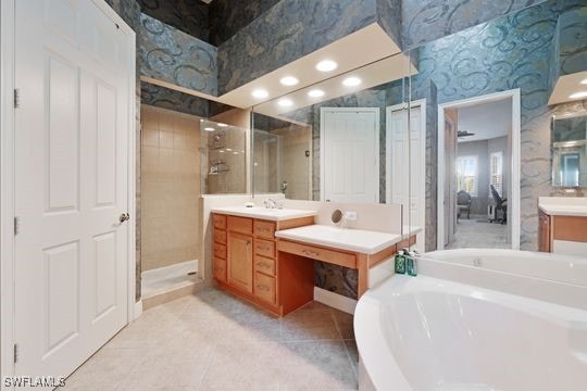 bathroom featuring tile patterned floors, independent shower and bath, and vanity