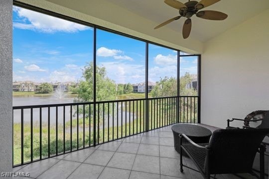 sunroom / solarium with a water view and ceiling fan