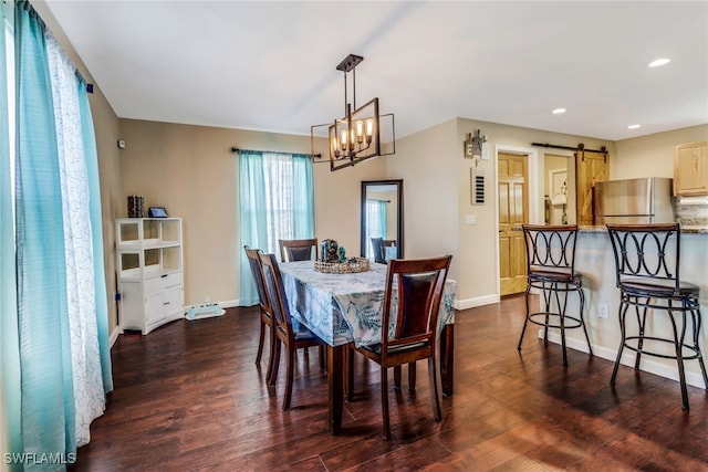 dining area with dark hardwood / wood-style flooring, a chandelier, and a barn door