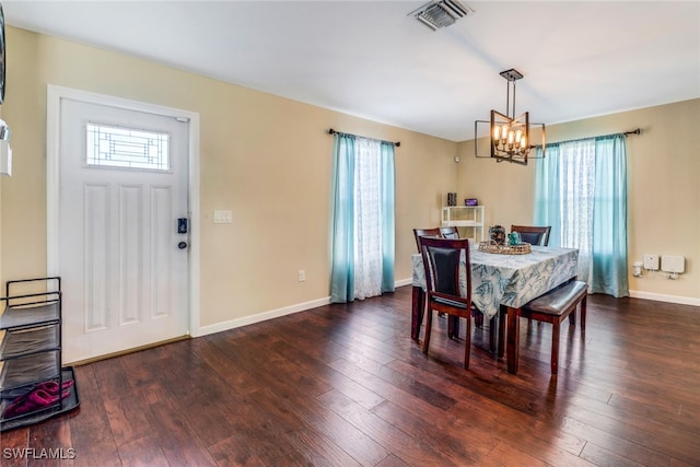 dining space featuring dark hardwood / wood-style floors and a notable chandelier