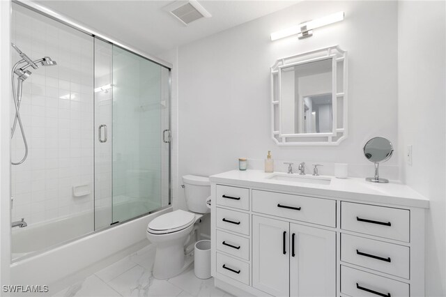 full bathroom featuring bath / shower combo with glass door, vanity, and toilet