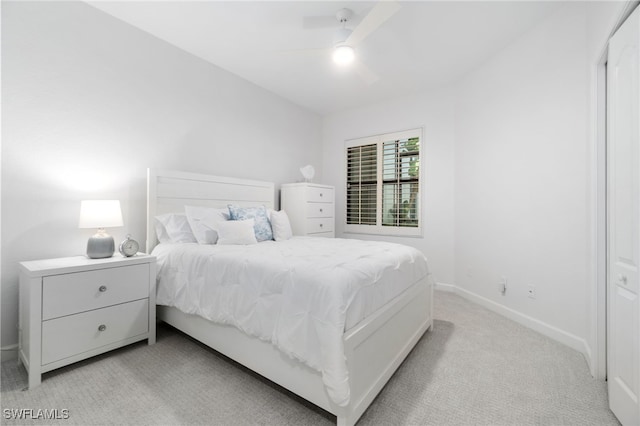 bedroom featuring light colored carpet, baseboards, and ceiling fan