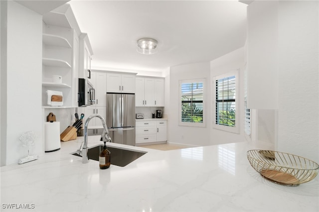 kitchen featuring sink, white cabinets, and stainless steel appliances