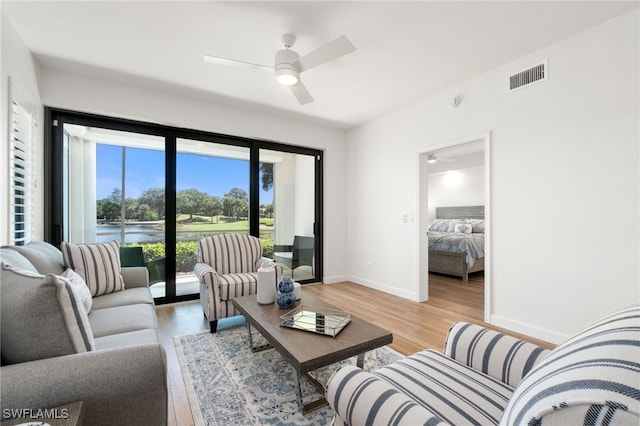 living room featuring light hardwood / wood-style floors and ceiling fan