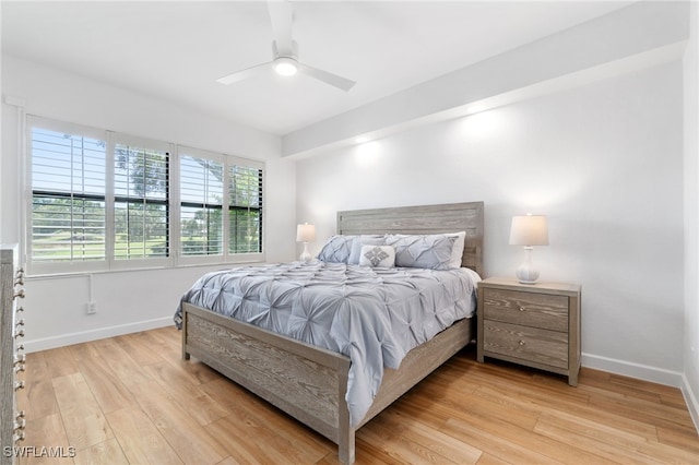 bedroom featuring baseboards, wood finished floors, and a ceiling fan