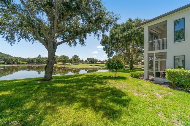 view of yard with a balcony and a water view