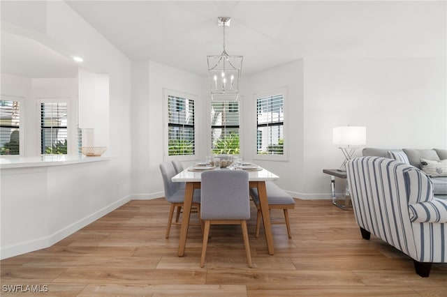 dining space with a chandelier, plenty of natural light, baseboards, and light wood-type flooring