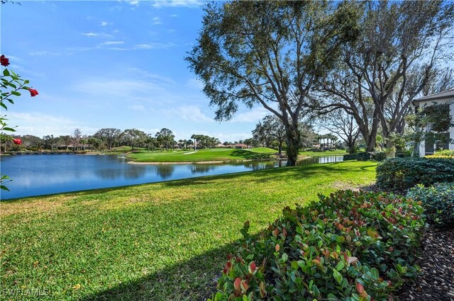 view of green lawn featuring a water view