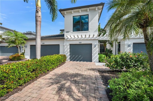 view of front of property featuring decorative driveway, stucco siding, and a garage