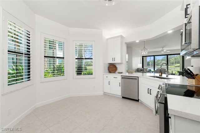 kitchen featuring stainless steel appliances, a sink, white cabinets, and baseboards