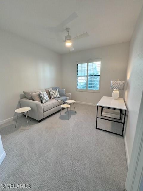 living room with baseboards, carpet, and a ceiling fan